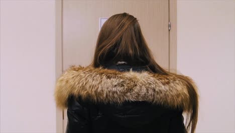 mujer de pie detrás de una puerta