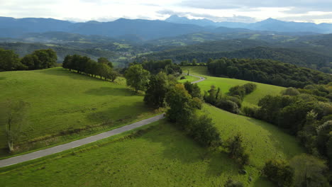 Eine-Luftaufnahme-Zeigt-Kurvenreiche-Straßen-Durch-Grüne-Wiesen,-Eingerahmt-Von-Hügeln