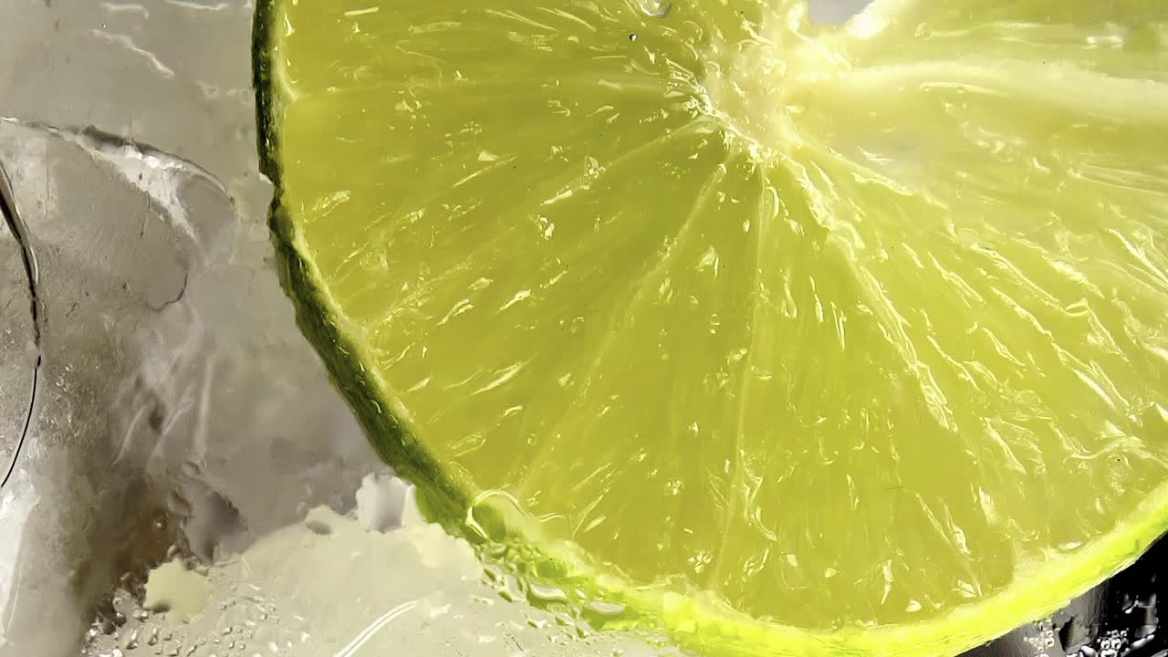 bebida gaseosa de soda y lima vertida en un vaso con cubitos de hielo