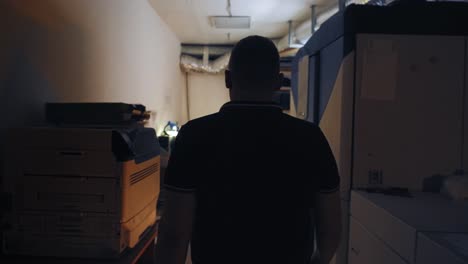 man walking in a dark equipment room