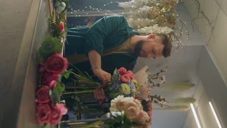 el florista recoge el ramo y mira a la cámara