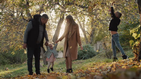 family with two children have fun in autumn park