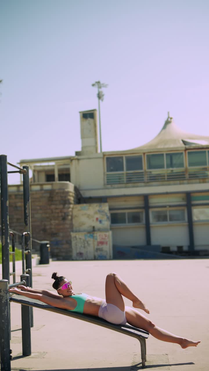 Young Woman Doing Sit-Ups on Incline Bench at Outdoor Gym