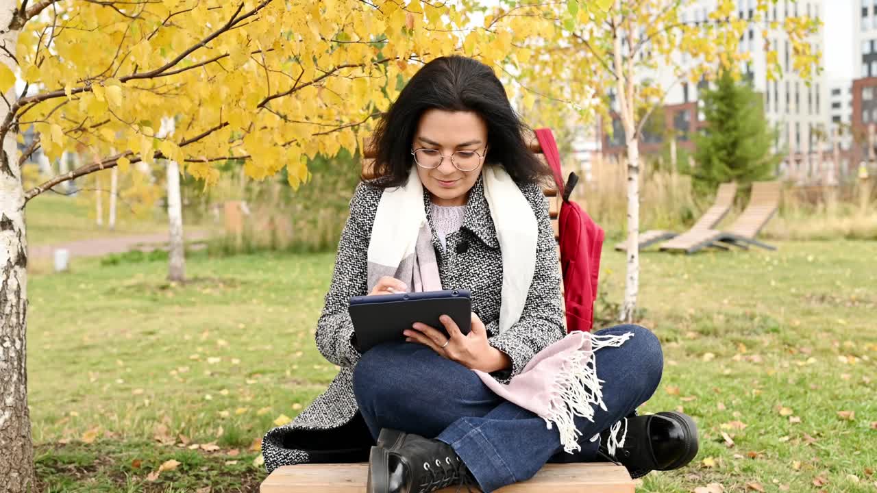 Woman with tablet PC in park