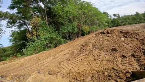 Pov-Beim-Bedienen-Eines-Kompaktladers,-Um-Einen-Kleinen-Erdhaufen-Zu-Bewegen,-Um-Eine-Große-Teichbaustelle-Zu-Ebnen