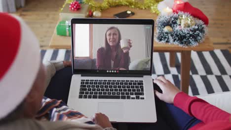 Madre-E-Hija-Afroamericanas-Usando-Una-Computadora-Portátil-Para-Una-Videollamada-Navideña-Con-Una-Mujer-En-La-Pantalla