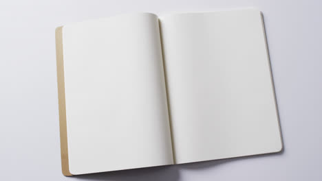 close up of open blank book with copy space on white background in slow motion