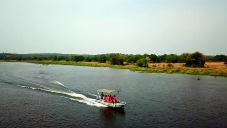 tourists in life vest ride speedboat in the lake, boat trip in africa