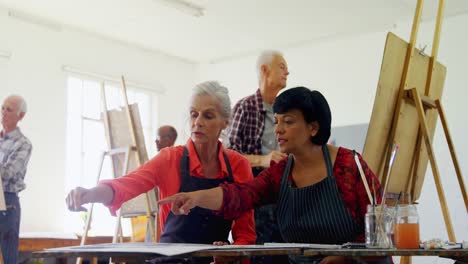 Drawing-teacher-interacting-with-artists-drawing-teacher-assisting-woman-in-drawing-4k