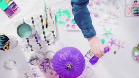 painting craft pumpkin with acrylic paint to create decorated mermaid halloween pumpkin.