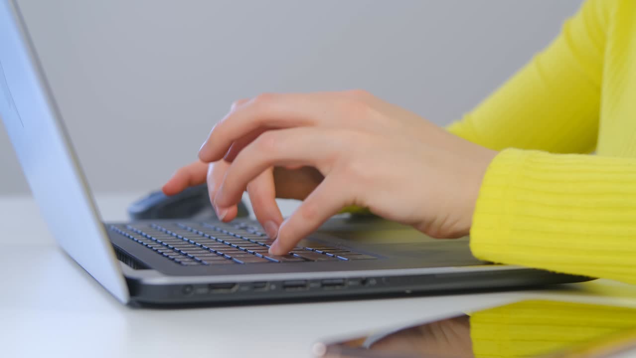 mujer independiente escribiendo texto en una computadora portátil en video de primer plano 4k. escritora independiente persona que hace trabajo a distancia en una portátil moderna. mujer trabajando desde casa durante el bloqueo