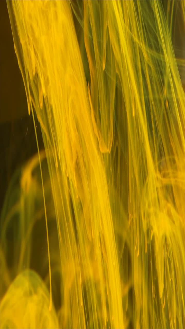 Inchiostro Giallo Vivace che si Agita e si Diffonde in Acqua Scura