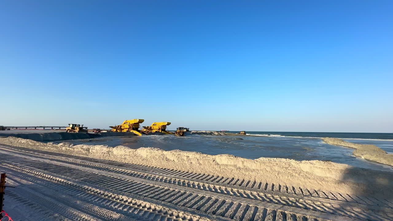 Wide view, sand pump station, bulldozer, and pier, beach replenishment