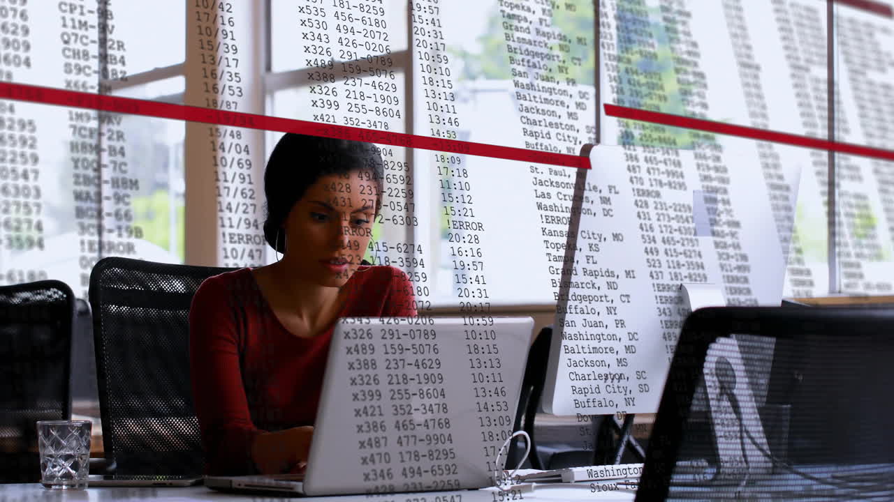 Animazione di elaborazione di dati finanziari su una donna d'affari birazziale che usa un laptop in ufficio