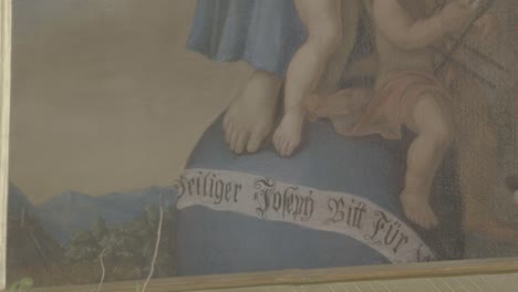 close-up of a painting with a banner "saint joseph supplicate for us