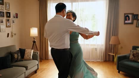 senior couple dancing in their living room