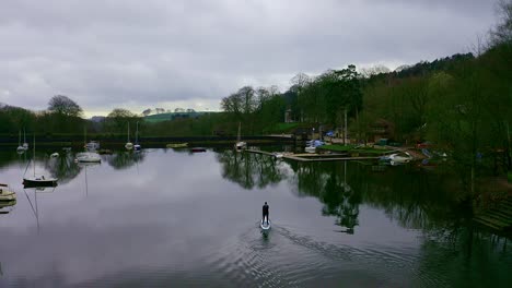 Wunderschöne-Luftaufnahme,-Aufnahmen-Von-Paddelboardern-Mittleren-Alters-Auf-Dem-Rudyard-See-Im-Derbyshire-Peak-District-Nationalpark,-Beliebter-Urlaubsort,-Touristenort-Mit-Friedlichem,-Ruhigem-Wasser