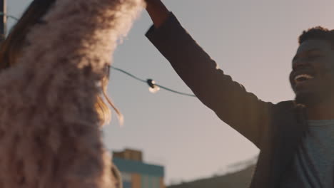 happy-young-multiracial-couple-dancing-on-rooftop-at-sunset-celebrating-relationship-having-fun-enjoying-playful-dance-together