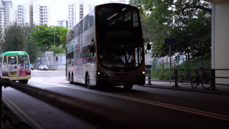 hongkong- may 20, 2022: hong kong never sleeps with busy streets with buses and cars passing by. busy scene of victoria city in hong kong during working hours.
