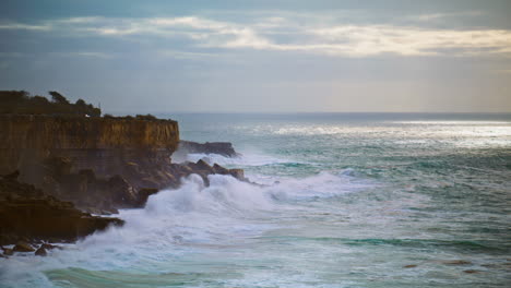 el océano lava los acantilados costeros en un día sombrío. el mar tormentoso rompe las rocas por la noche.