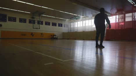 male walking up and looking behind - strong athletic muscular black man standing on basketball court looking around in 4k