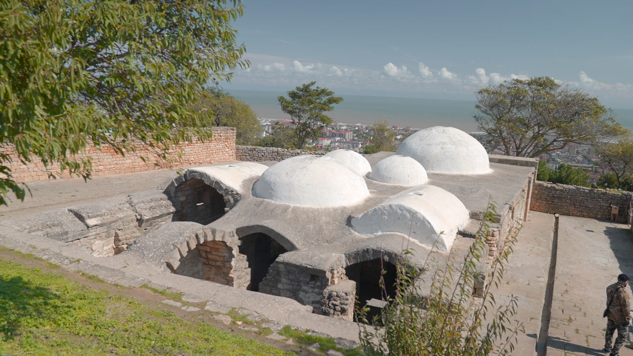 White Domed Bathhouse On Coastal Hillside, Sunlit Plaster Domes And Stone Arches Beside Green Terrace. Creative