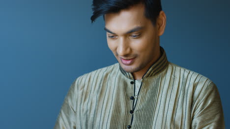 close-up view of indian young man in traditional clothes texting on the phone