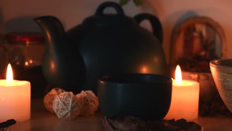 relaxing background detail shot of an herbal tea shop, with candles with flickering flames, a tea pot and a cup with steam coming out