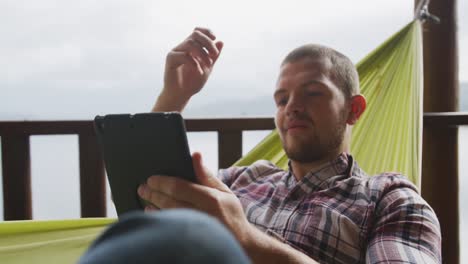 Hombre-Caucásico-Pasando-Tiempo-En-Casa-Usando-Una-Tableta-Y-Sonriendo