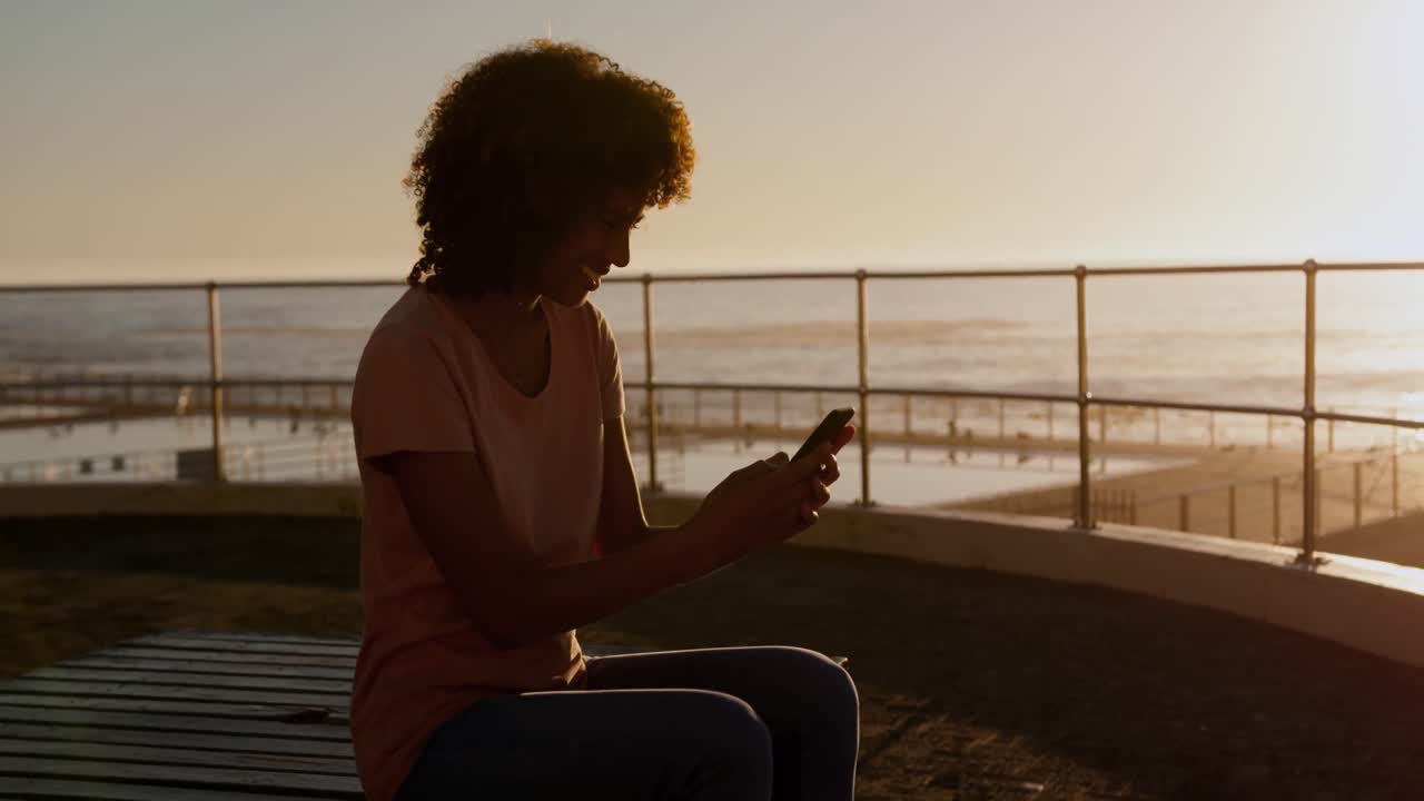 Donna che usa il telefono al tramonto