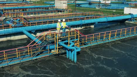 male specialists talking at a wastewater treatment plant