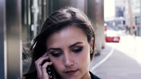 atractiva mujer de negocios viajera que usa un teléfono inteligente caminando en la ciudad de londres