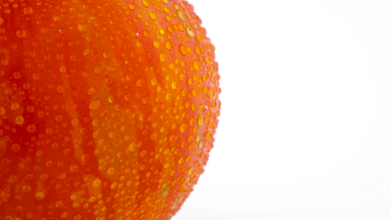 빨간색 지구 줄무 토마토의 매크로 촬영: 색 배경에 고립 된 회전 테이블에서 천천히 회전하는 토마토 반 프레임.