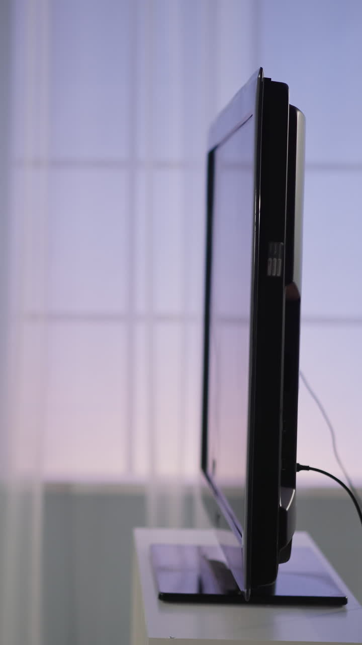 arrojado por un fanático de deportes enojado bola blanca vuela en la pantalla de la televisión contra la ventana de primer plano en cámara lenta. reacción emocional en el fracaso del club de fútbol favorito