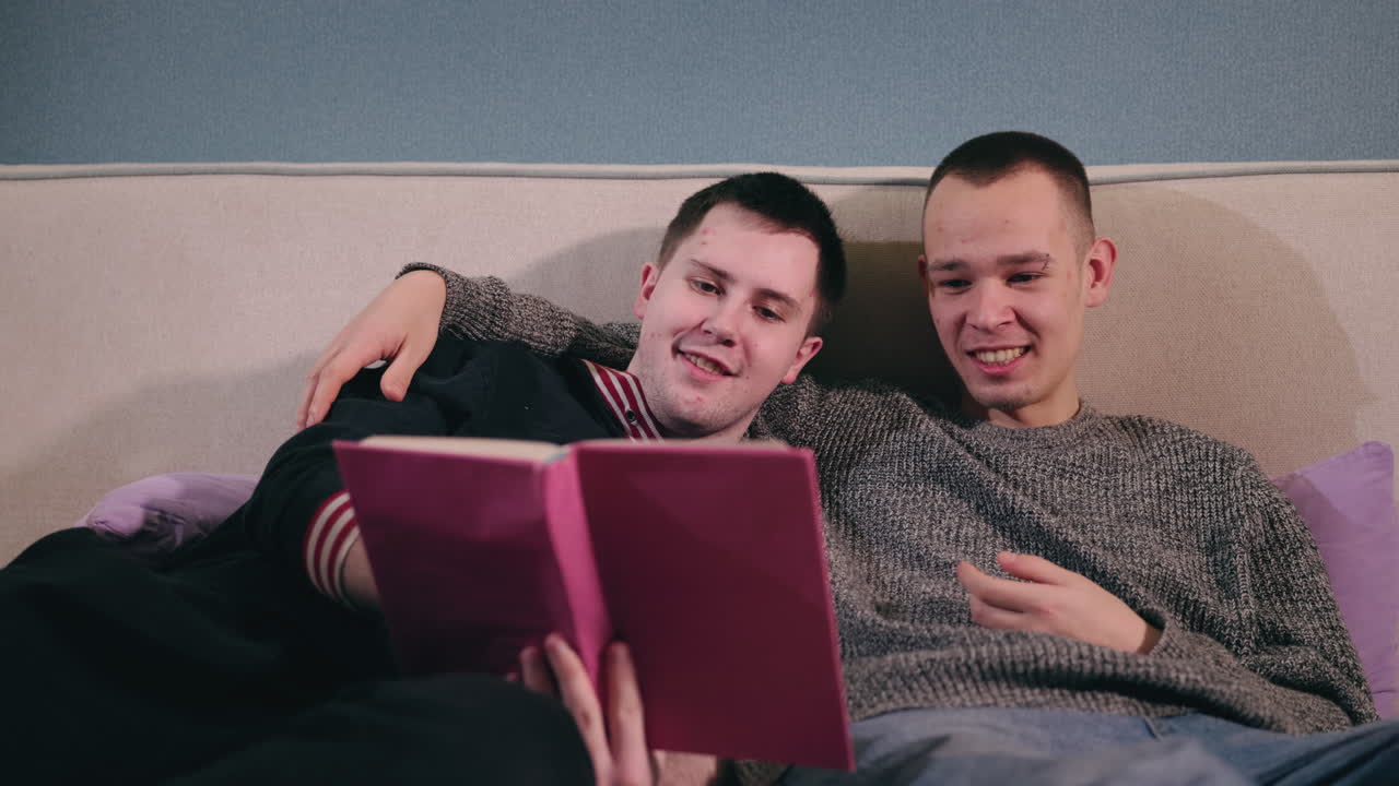 двое мужчин читают вместе на диване