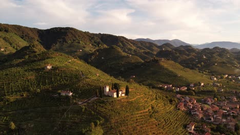 Aerial-landscape-view-over-the-famous-prosecco-hills-with-vineyard-rows-and-a-small-church,-in-Italy