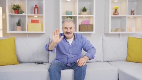 un anciano saludando a la cámara.