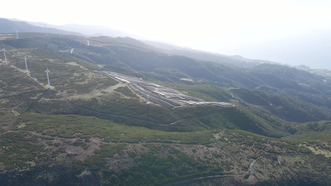 vista aérea de una granja fotovoltaica y una granja eólica en la cima de una montaña en la isla de paul da serra madeira