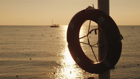 dawn on the sea in the foreground hangs a life ring in the distance the ship is visible scenic lands