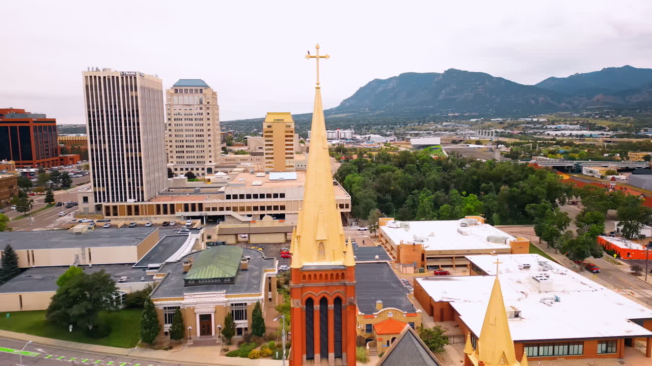 Colorado Springs, USA, 22 July 2025: Footage at the golden steeple of the cathedral. Aerial view on the cityscape of Colorado Springs, Colorado, USA surrounded by the mountains