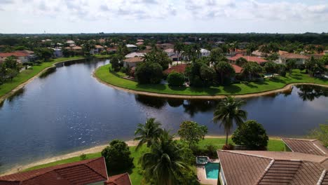 Jib up drone shot of West Palm Beach residential area and real estate with a lake during the day in Florida, USA