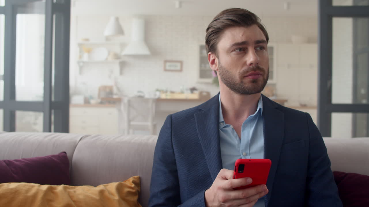 Giovane uomo d'affari che chatta sullo smartphone nel suo ufficio domestico