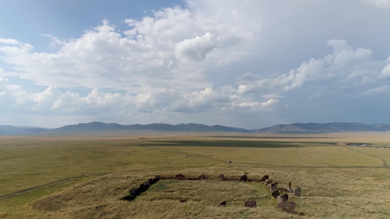 Weite Felder, unendlicher Himmel und sanfte Hügel. Eine ruhige Landschaft mit klarem blauem Himmel und flauschigen weißen Wolken