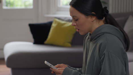 stressed and worried woman with financial worries about cost of living crisis debt and paying bills at home looking at mobile phone