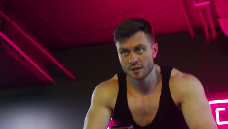 facial portrait of a sportsman. focused athlete exercising on a treadmill in modern fitness club. handsome young man with muscular body training indoors.