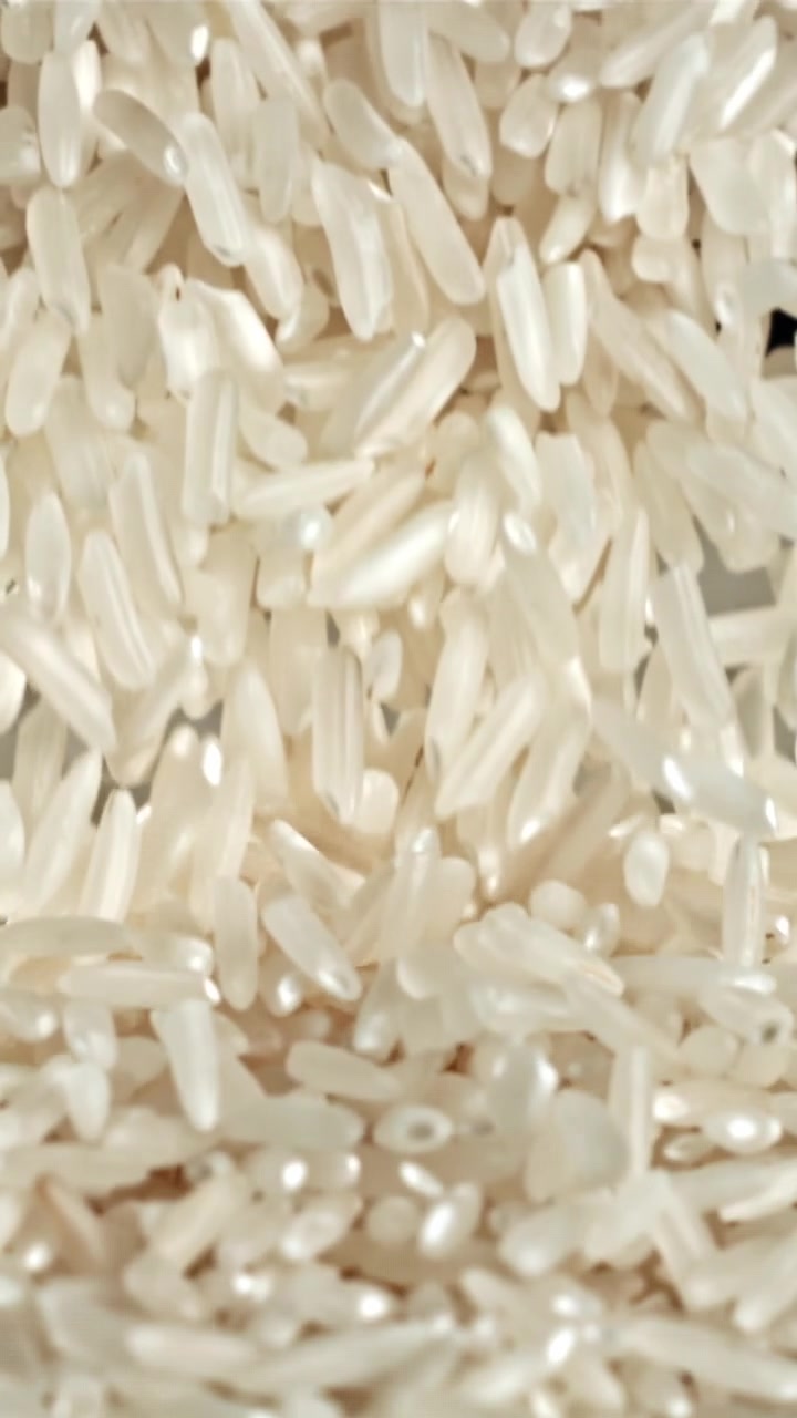 Primo piano al rallentatore di chicchi di riso bianco che cadono