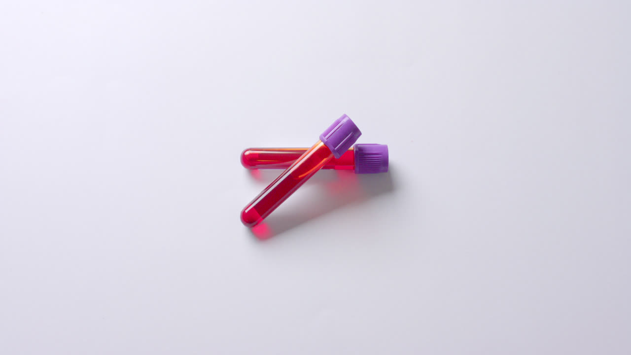 Close up of blood samples on white background with copy space, slow motion