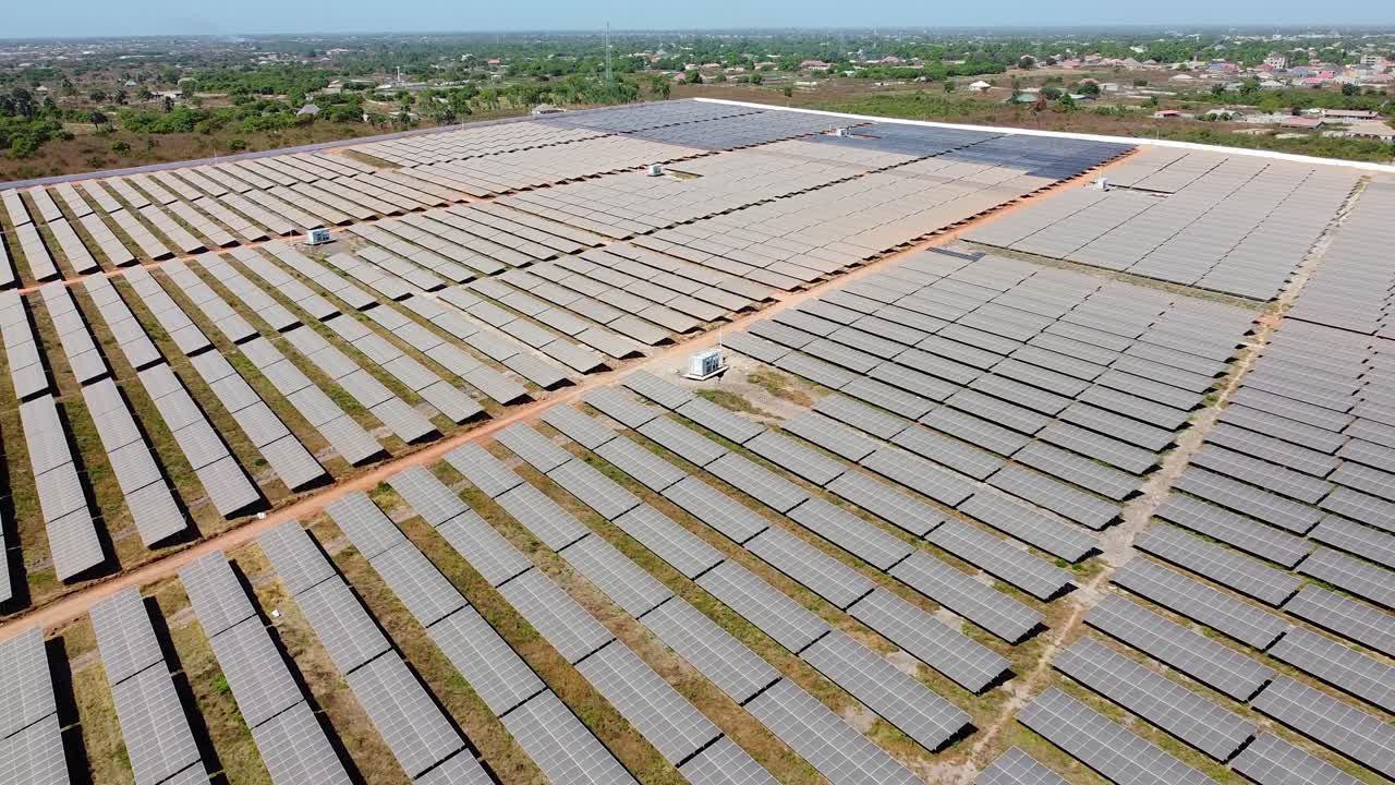 High angle reverse overview of solar field inverters and very dirty panels arrays