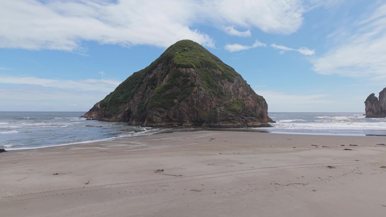 Imagens de drone de uma praia remota de areia cercada por exuberantes falésias verdes na Ilha de Chiloé, Chile. Paisagem costeira pacífica do Pacífico com natureza intocada