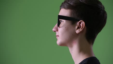 young handsome iranian teenage boy against green background